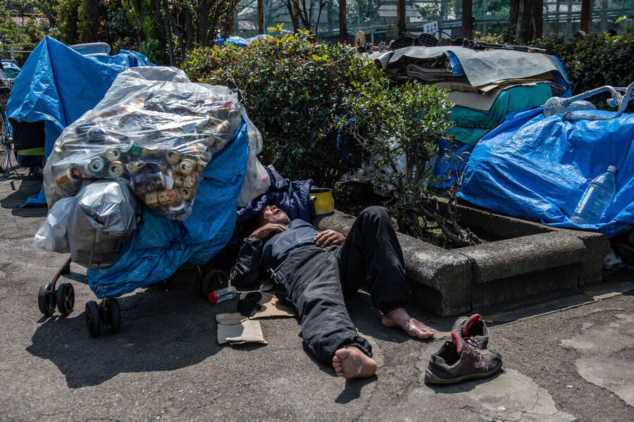 Clicare per ingrandire homeless man sleeps in a park in Tokyo